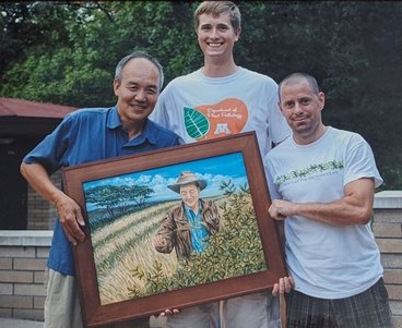 Yue Jin, Pablo, and Matt Rouse hold a framed picture of Yue